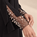 Close-up of The Huriya Black Pearl Mesh Cuff Abaya, featuring pearl-embellished sheer mesh sleeves and black crepe detailing