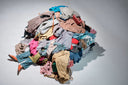 Pile of layered clothing in different colors and textures, illustrating the concept of layering behind two-layer abaya designs