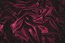 Rich burgundy velvet fabric with soft folds and sheen for winter abayas