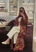 Woman taking a selfie in a store with shelves displaying shoes and bags.