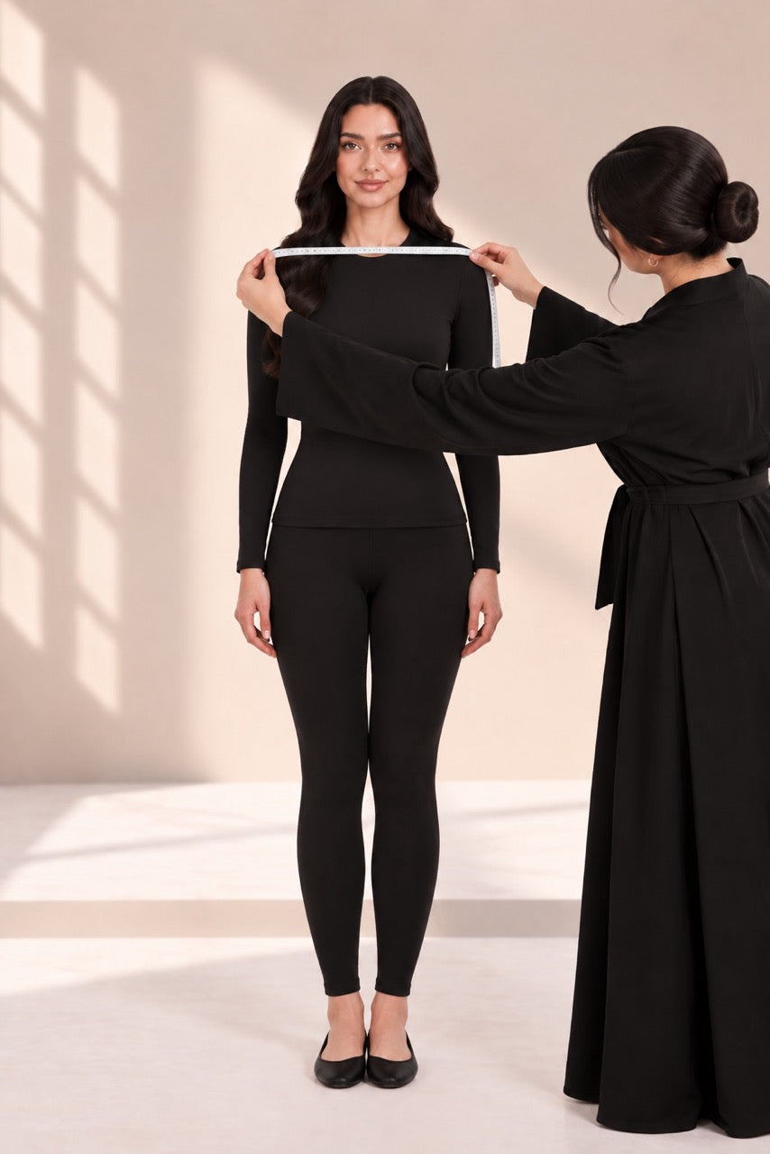 Measuring shoulder width across the back, with a helper