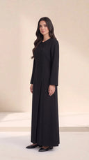 The Samira Curved Asymmetric Button Abaya, in Black, side view