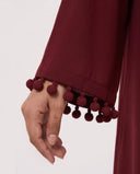The Zeina Pom-Pom Cuff Abaya, in Burgundy, detail view